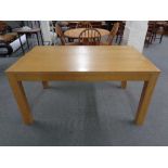 A contemporary oak effect dining table together with a pair of pine dining chairs