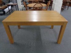 A contemporary oak effect dining table together with a pair of pine dining chairs