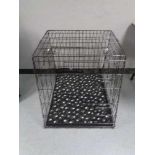 A folding black metal dog cage, height 70 cm, width 68 cm, depth 84 cm.