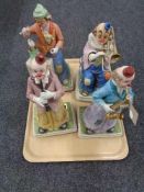 A tray of four musical pottery clown figures