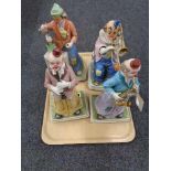 A tray of four musical pottery clown figures