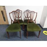 A set of four inlaid mahogany shield backed dining chairs