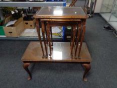 A nest of three walnut glass topped tables on cabriole legs together with similar coffee table