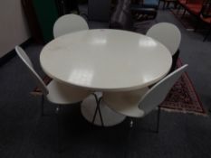 A white circular dining table and four chairs