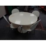 A white circular dining table and four chairs