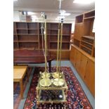 A brass and glass two tier coffee table together with four brass standard lamps