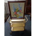 A tapestry fire screen on brass feet together with a gilt three tier trolley