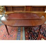 A twentieth century circular mahogany dining table with three leaves