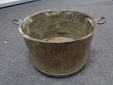 A nineteenth century copper twin handled pot, width 44 cm.