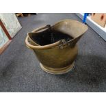 An antique brass coal bucket