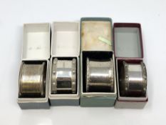 Four boxed silver napkin rings including two Lindisfarne pattern
