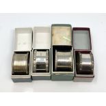 Four boxed silver napkin rings including two Lindisfarne pattern