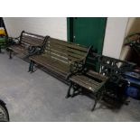 A pair of cast iron wooden slatted garden benches together with matching side table and pair of