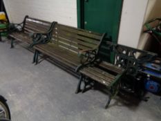 A pair of cast iron wooden slatted garden benches together with matching side table and pair of