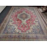 A machine made Persian design woolen carpet on pink ground, 383cm by 281cm.