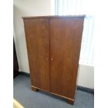 A mid century stained beech double door cupboard