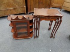 A nest of three mahogany tables together with a glazed door wall mounted cabinet