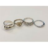 Four white metal dress rings