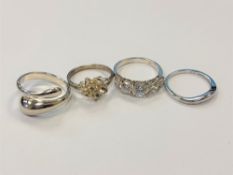 Four white metal dress rings