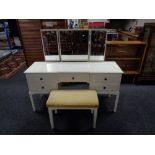 A white knee hole dressing table fitted with five drawers with triple mirror and stool