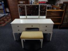 A white knee hole dressing table fitted with five drawers with triple mirror and stool