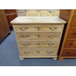 An antique stripped pine four drawer chest