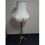 A brass Arts and Crafts rise and fall standard lamp with shade