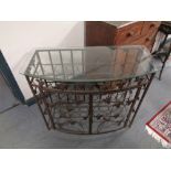 A wrought metal glass topped wine cabinet