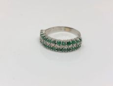 An 18ct white gold emerald and diamond half eternity ring,