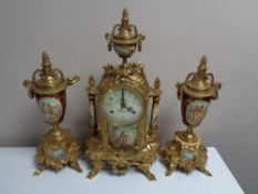 A three piece continental brass and ceramic clock garniture.