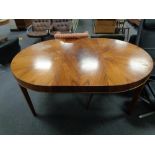 A circular mid century Danish extending dining table with leaf