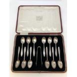 A boxed set of twelve silver teaspoons with pair of matching tongs,