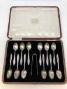 A boxed set of twelve silver teaspoons with pair of matching tongs,