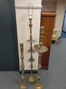 An Indian brass standard lamp together with two similar floor standing candlesticks