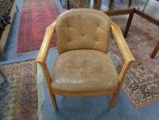 A twentieth century beech framed armchair in tan buttoned leather