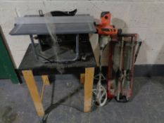 An electric table saw on stand together with a cement mixer and tile cutter CONDITION