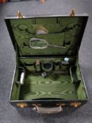 A Twentieth Century black vanity case with a fitted interior and lined with green satin,