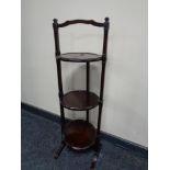 A mahogany three tier folding cake stand