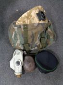 A military style camo bag containing WW II water bottle, gas mask,