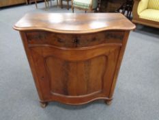 A late nineteenth century mahogany serpentine fronted cabinet