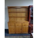 A pine dresser fitted with doors and cupboard beneath