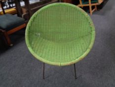 A mid century wicker chair on metal legs