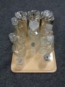 A tray of decanters and cruet bottles, three metal tea caddies.