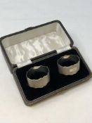 A boxed pair of oval silver napkin rings with engine turned decoration,