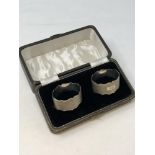 A boxed pair of oval silver napkin rings with engine turned decoration,