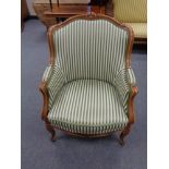 A beech framed salon armchair in green striped fabric