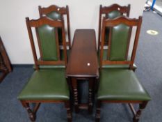 An Old Charm drop leaf table and four chairs upholstered in green leather