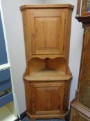 A stripped pine corner cabinet