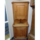 A stripped pine corner cabinet