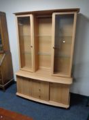 A display cabinet fitted double door cabinet and three drawers in pine finish